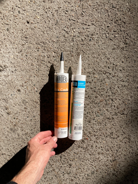 Two Bright White Bottles Of Caulk